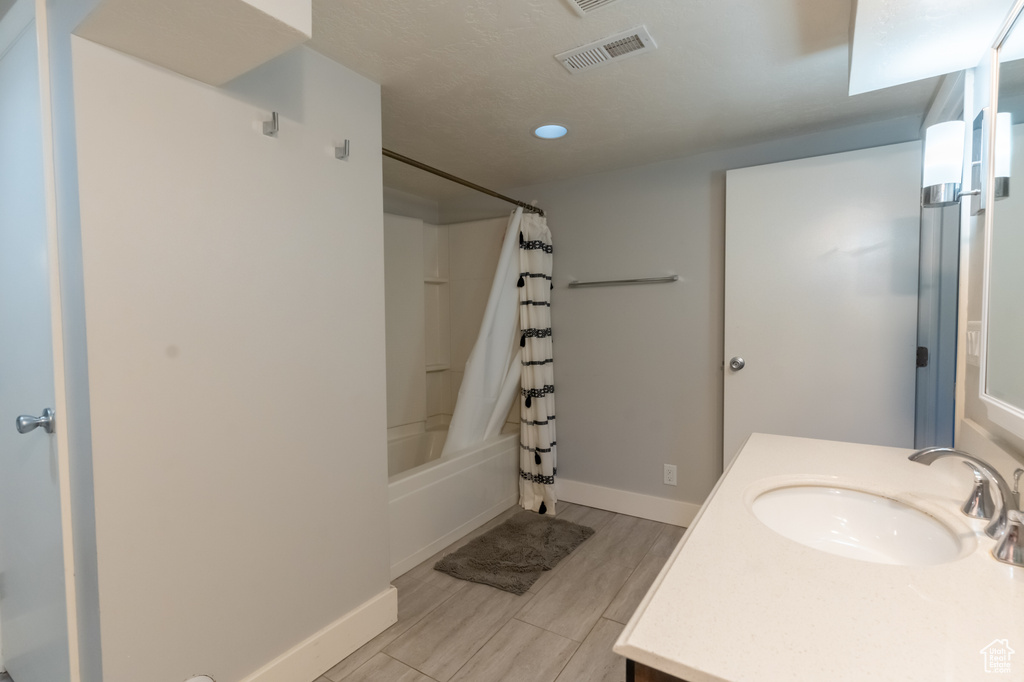 Bathroom with shower / tub combo, vanity, and hardwood / wood-style floors