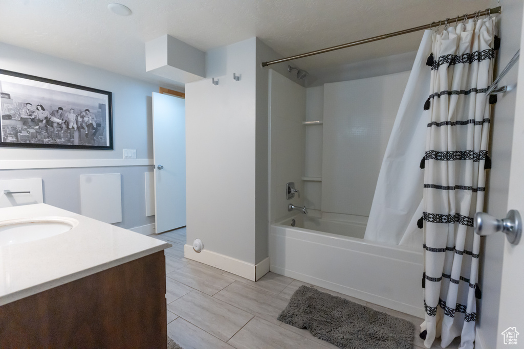 Bathroom with vanity, tile floors, and shower / tub combo with curtain