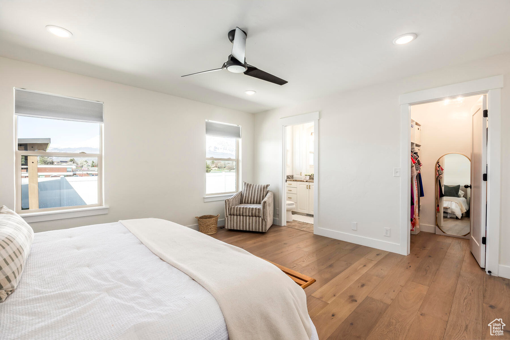 Bedroom with ceiling fan, a closet, ensuite bath, light hardwood / wood-style flooring, and a spacious closet