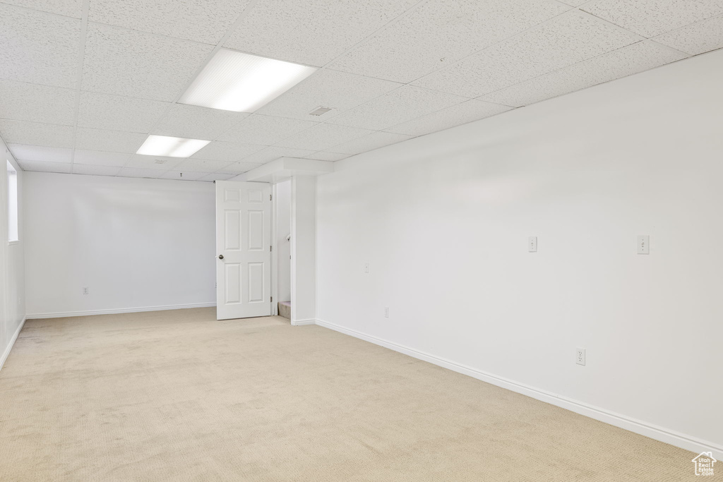 Interior space with light carpet and a paneled ceiling