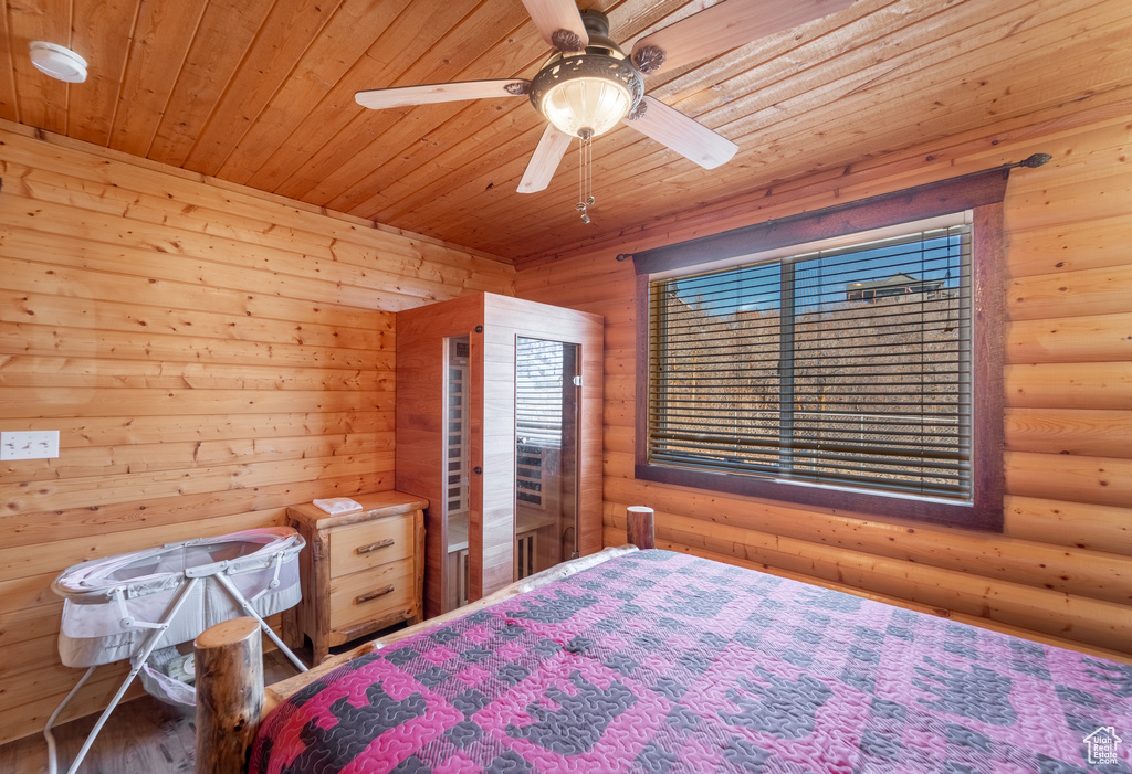 Bedroom with log walls, ceiling fan, and wooden ceiling