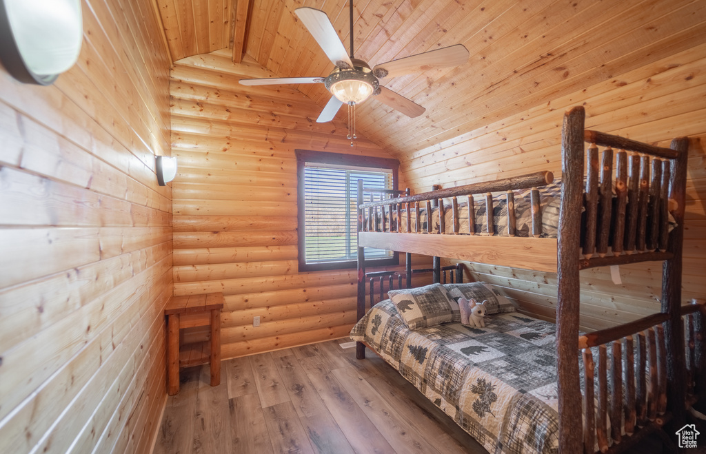 Bedroom featuring light hardwood / wood-style floors, ceiling fan, wooden ceiling, and lofted ceiling