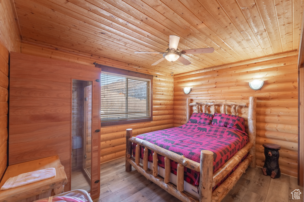 Bedroom featuring light hardwood / wood-style flooring, log walls, ceiling fan, and wooden ceiling