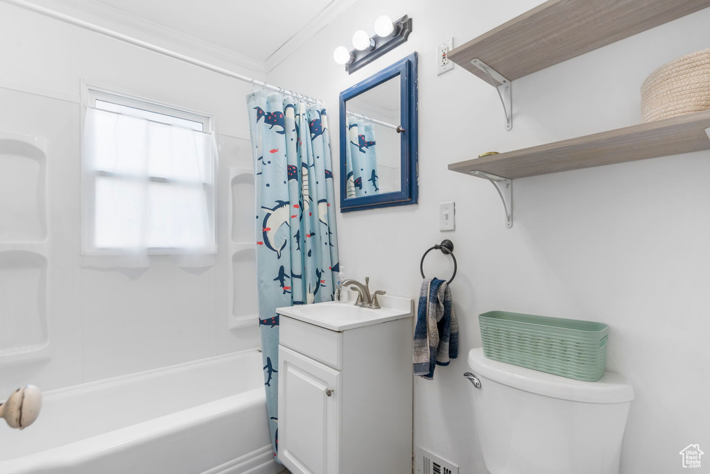 Full bathroom with shower / bath combo, crown molding, toilet, and vanity with extensive cabinet space