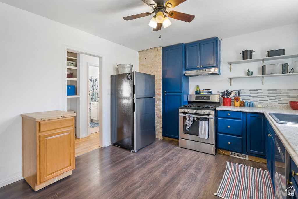 Kitchen with ceiling fan, tasteful backsplash, dark wood-type flooring, black refrigerator, and stainless steel gas range oven
