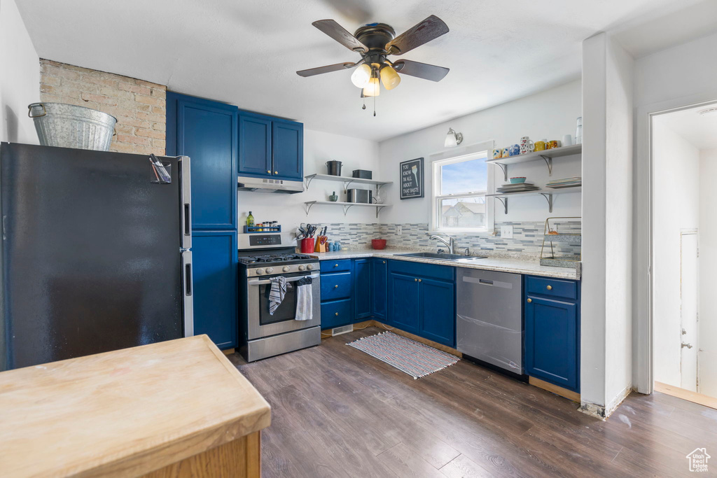 Kitchen with ceiling fan, sink, backsplash, stainless steel appliances, and dark hardwood / wood-style floors