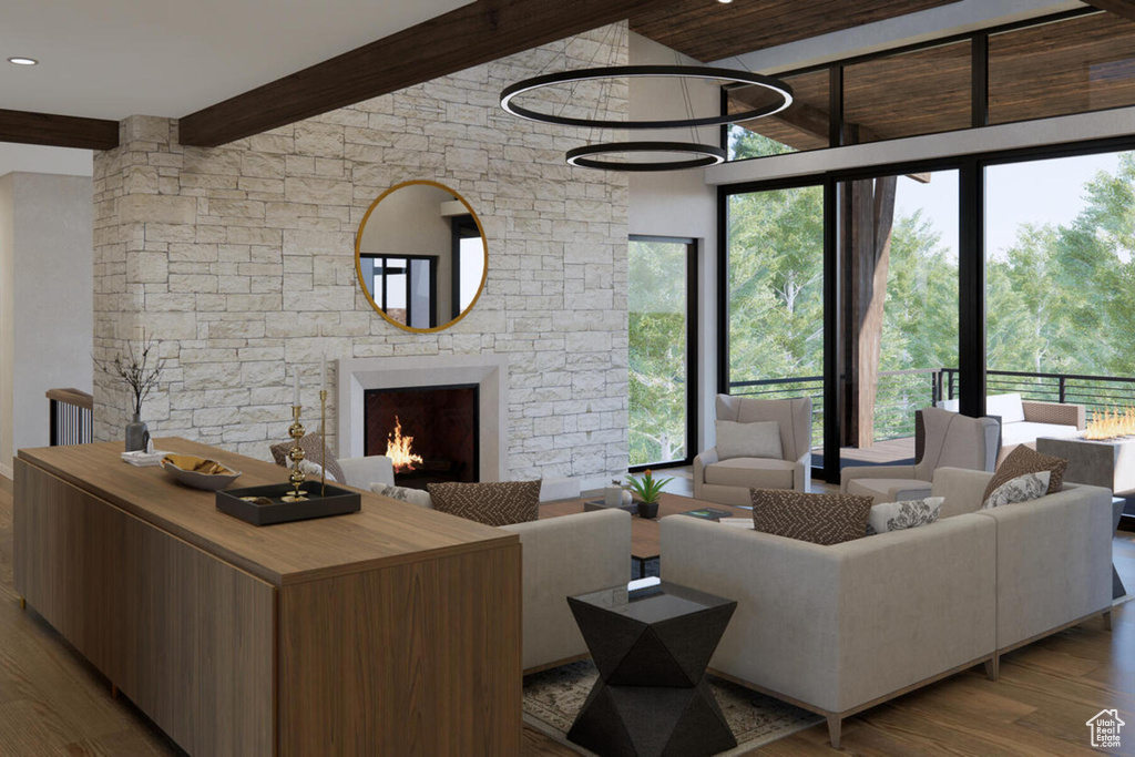 Living room featuring beamed ceiling, a stone fireplace, dark hardwood / wood-style floors, and a towering ceiling