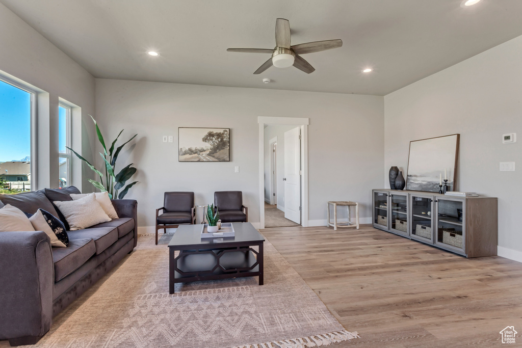 Living room with a wealth of natural light, ceiling fan, and light wood-type flooring