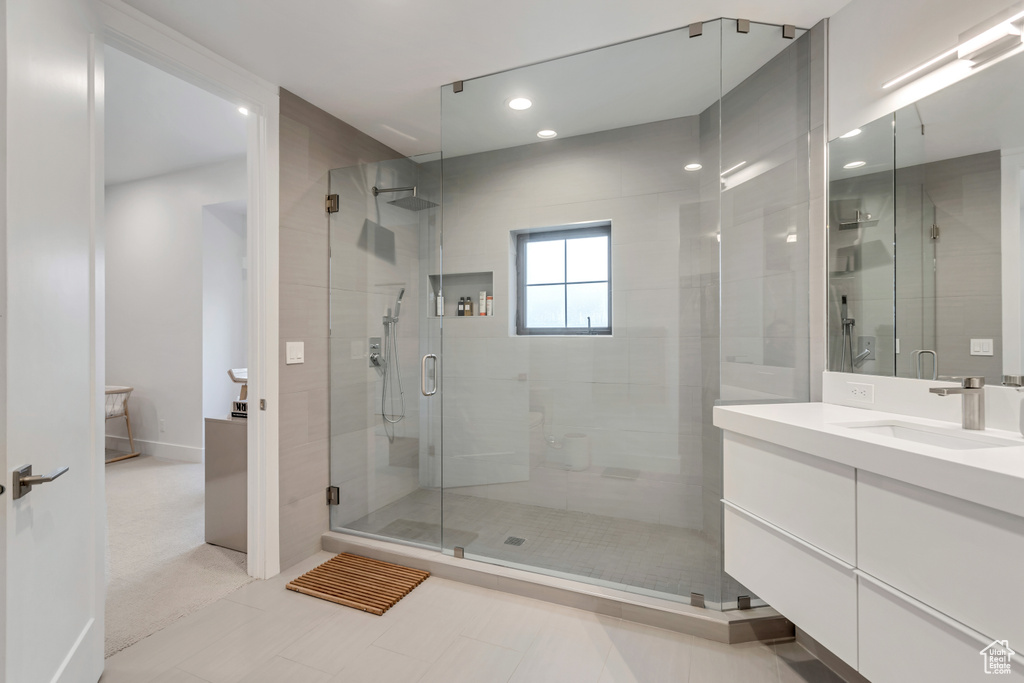 Bathroom featuring tile floors, vanity, and an enclosed shower