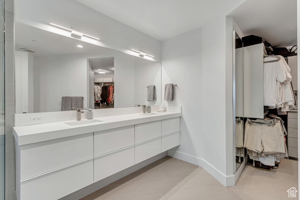 Bathroom featuring tile floors and dual vanity