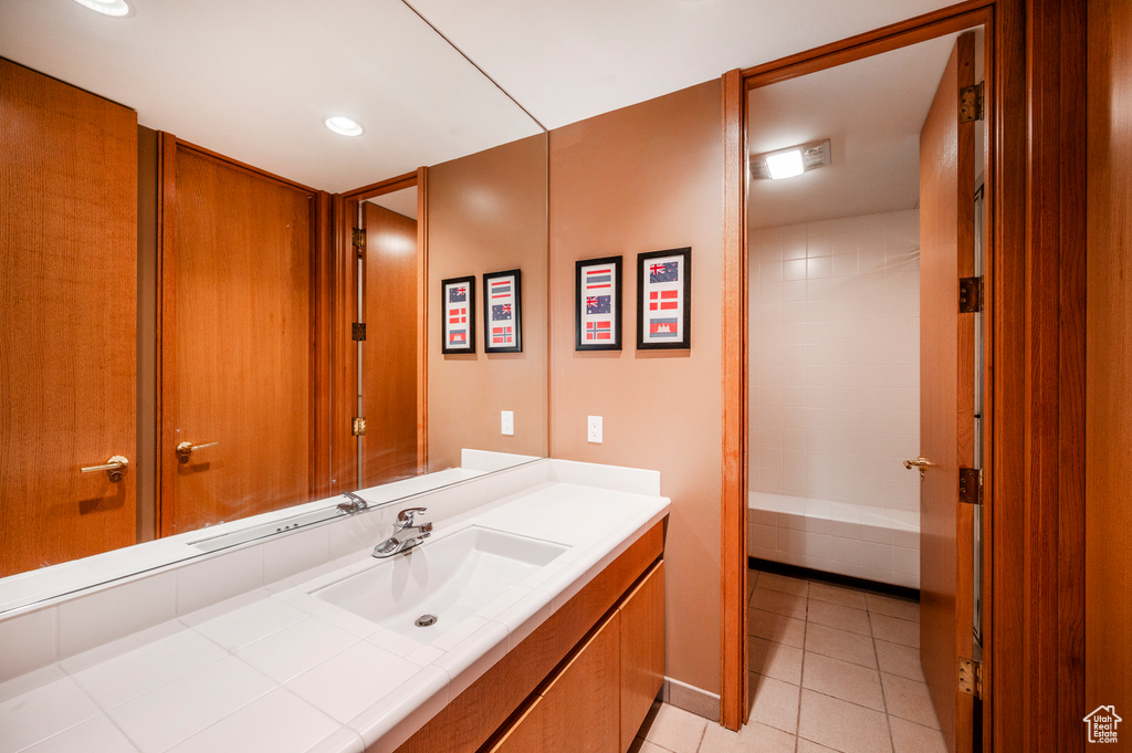 Bathroom featuring washtub / shower combination, large vanity, and tile flooring