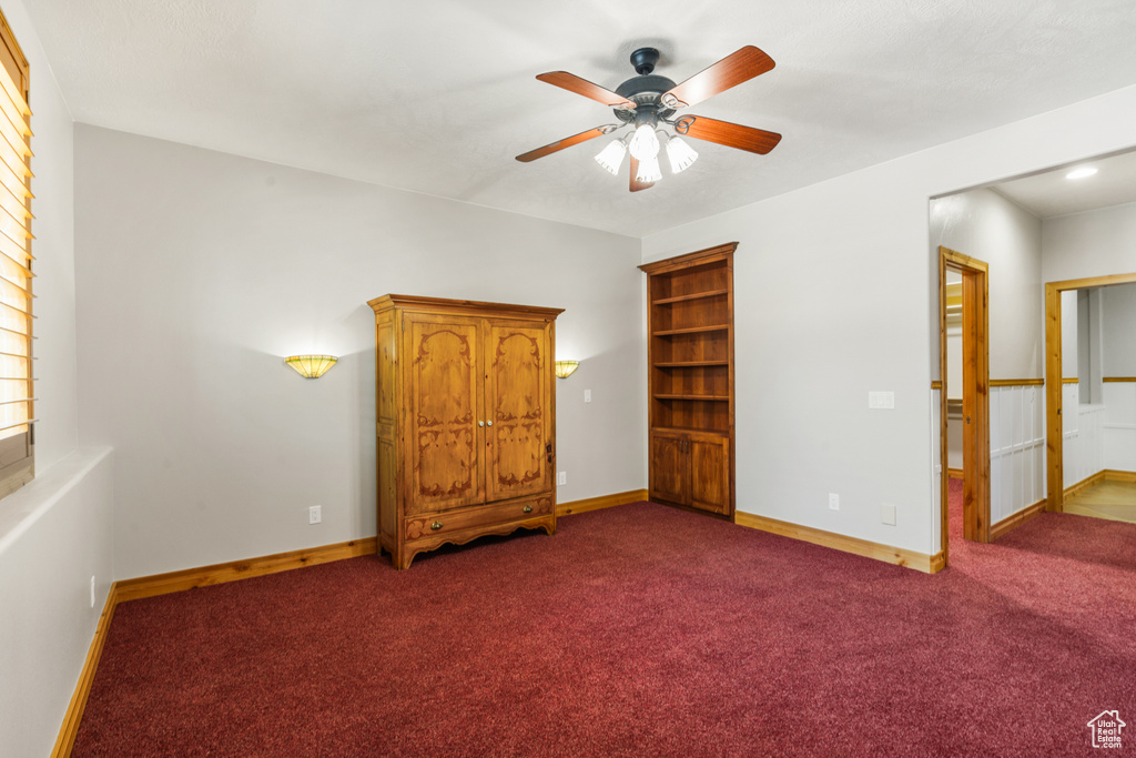 Interior space featuring ceiling fan and dark carpet