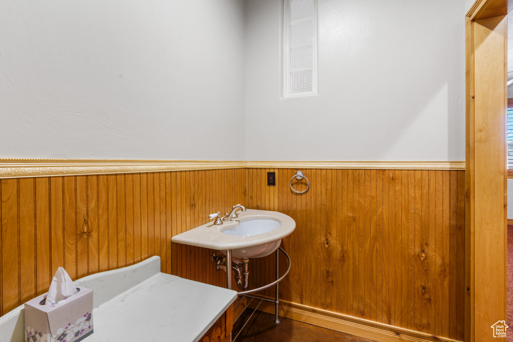 Bathroom featuring wooden walls