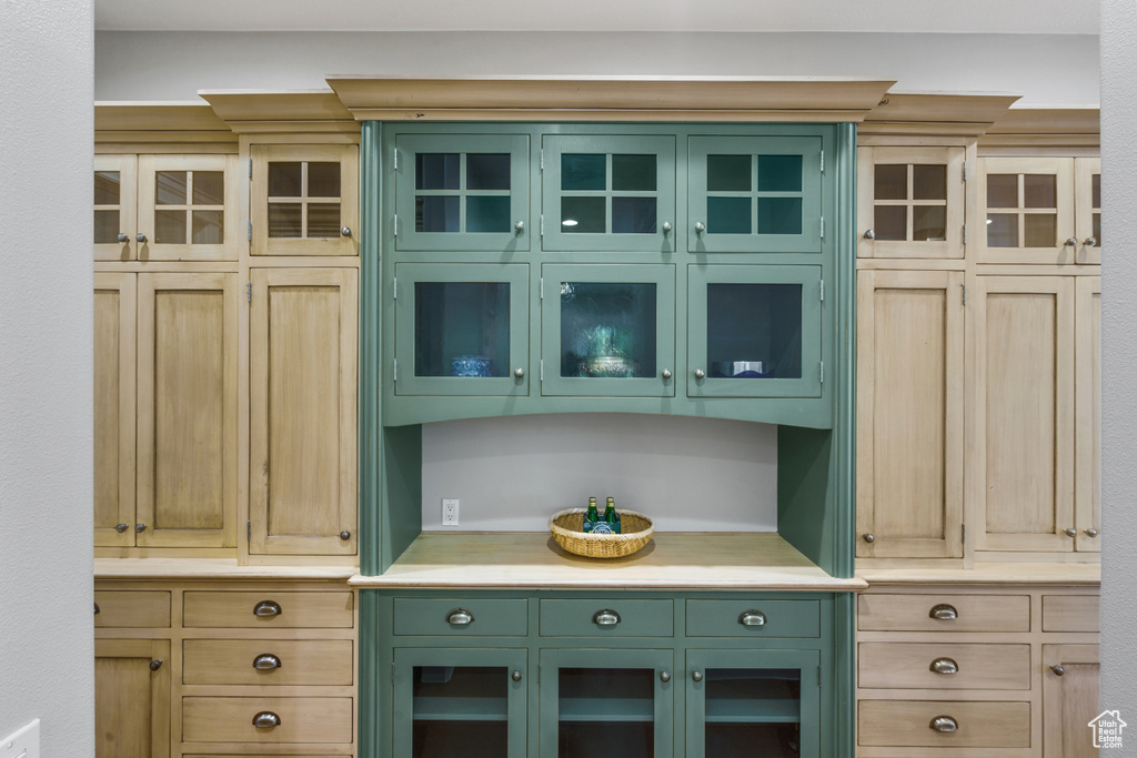 Kitchen with green cabinetry and light brown cabinets