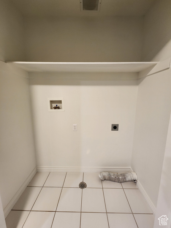 Washroom with hookup for a washing machine, light tile floors, and electric dryer hookup