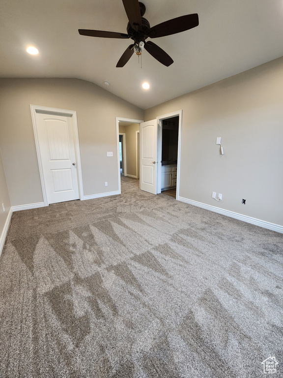Unfurnished bedroom featuring vaulted ceiling, ceiling fan, and light carpet