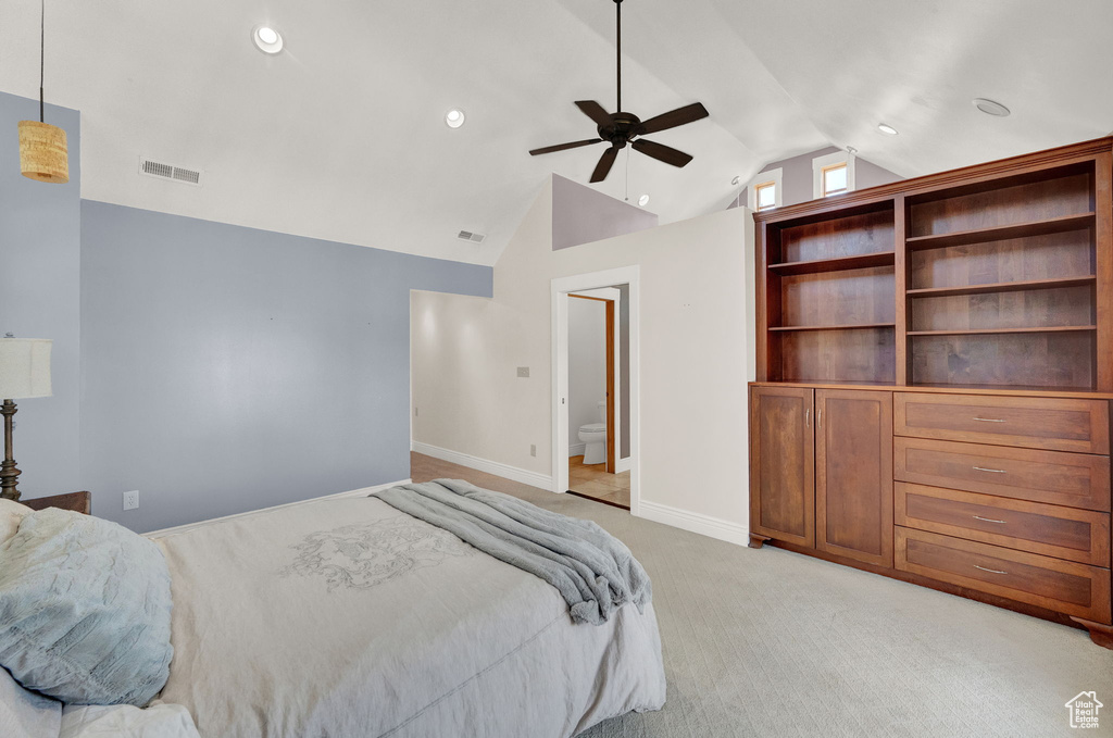 Bedroom featuring light carpet, vaulted ceiling, ceiling fan, and connected bathroom