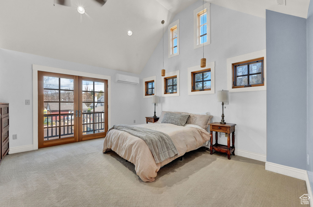 Carpeted bedroom featuring high vaulted ceiling, access to exterior, and a wall mounted AC