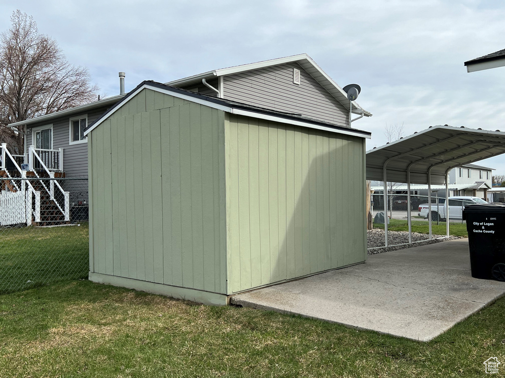 View of shed / structure with a carport and a lawn