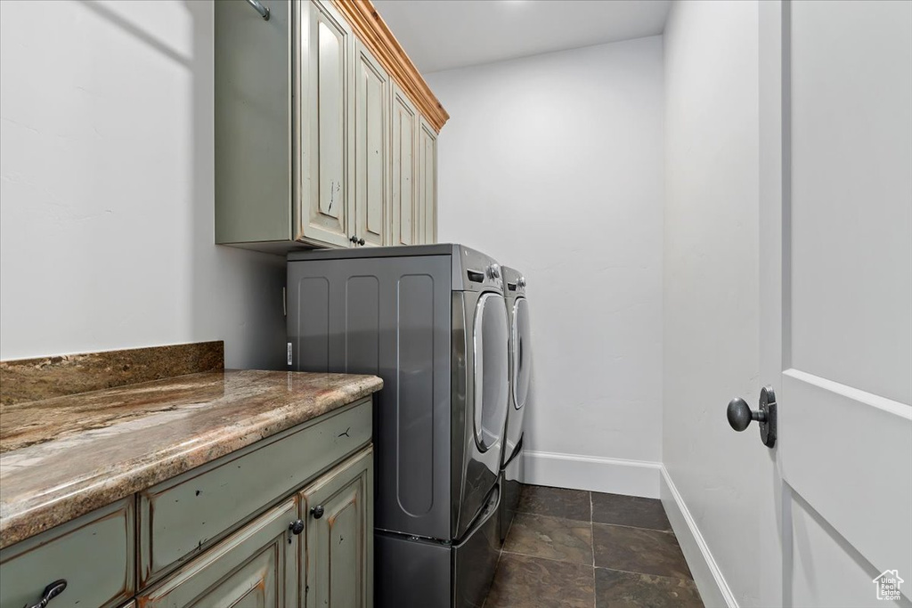 Laundry area with cabinets, washing machine and clothes dryer, and dark tile floors