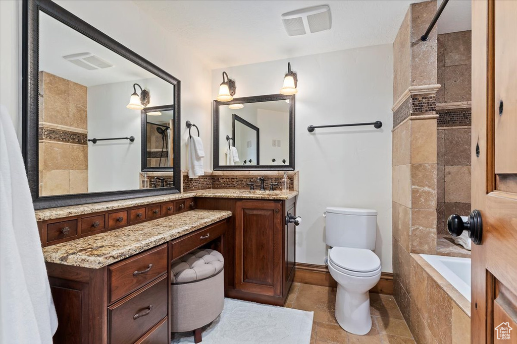 Full bathroom featuring shower / bath combo, vanity, toilet, and tile flooring