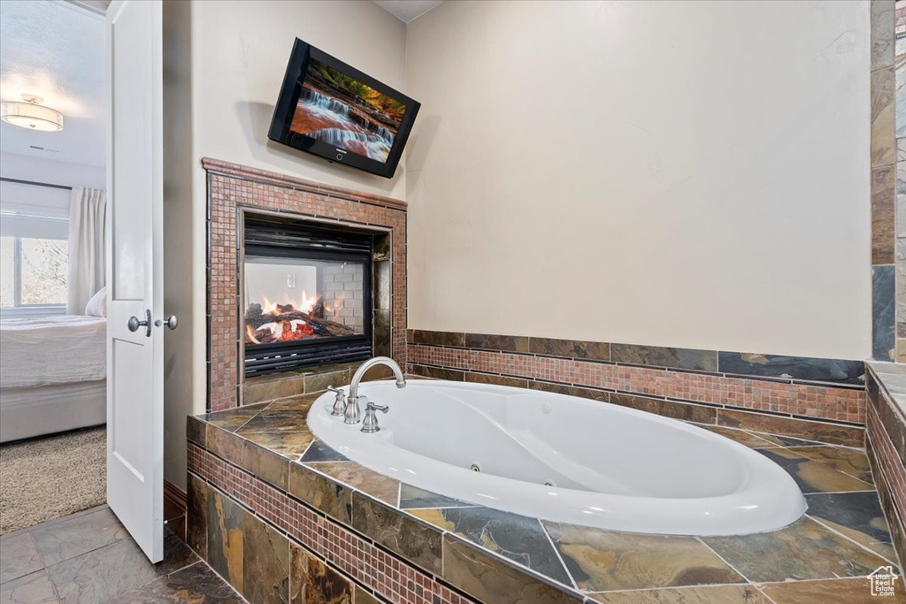Bathroom with a multi sided fireplace and tile flooring