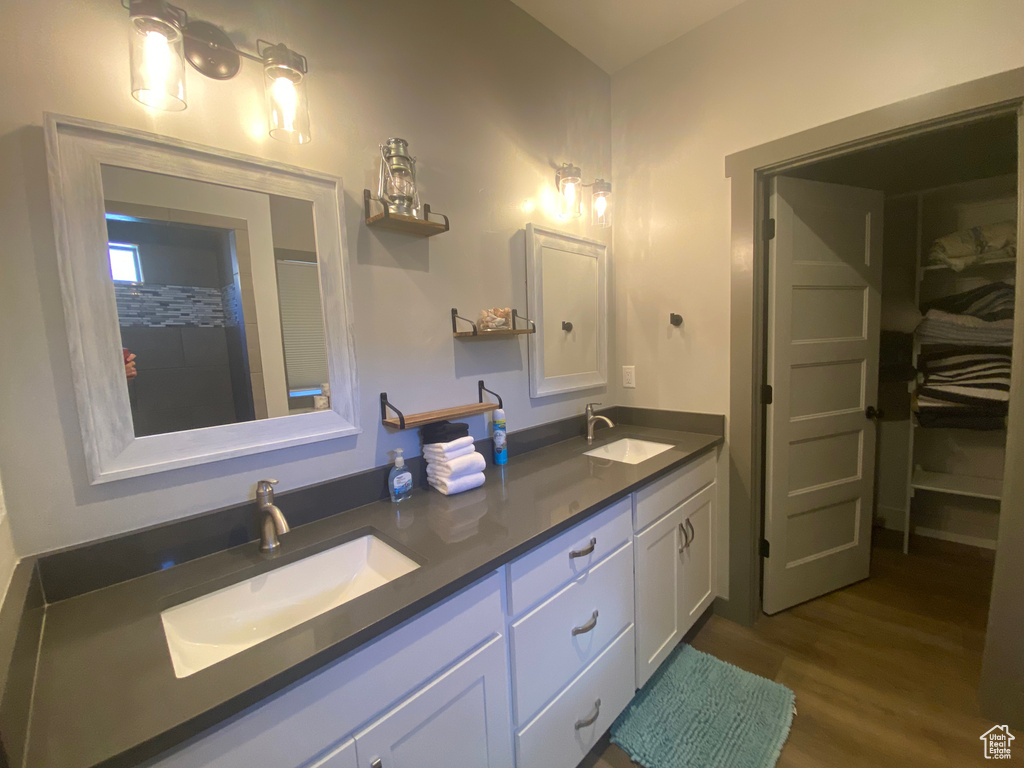 Bathroom featuring hardwood / wood-style flooring and dual vanity