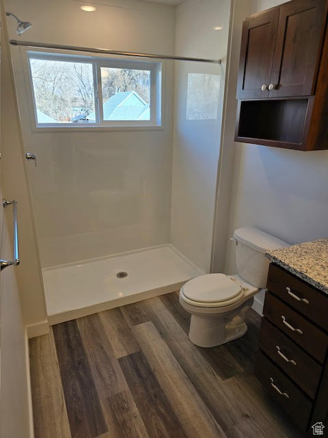 Bathroom with toilet, hardwood / wood-style flooring, and plenty of natural light
