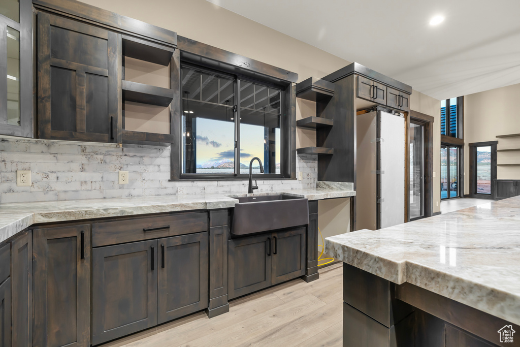Kitchen featuring dark brown cabinetry, sink, and backsplash