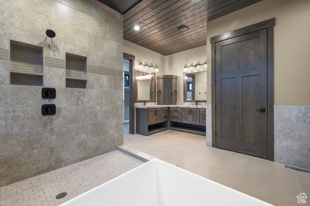 Bathroom featuring double vanity, tile floors, wooden ceiling, and plus walk in shower