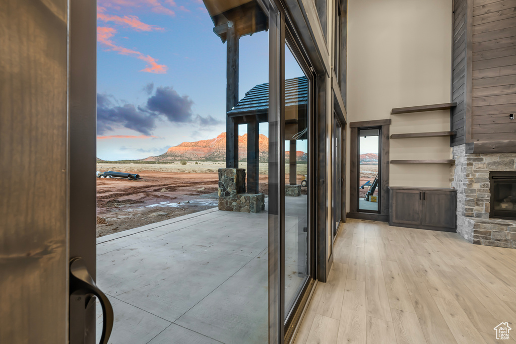 Entryway with a mountain view, light hardwood / wood-style flooring, and a stone fireplace