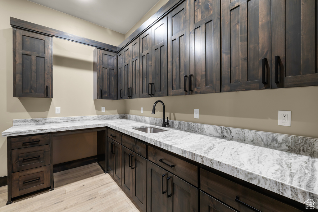 Kitchen featuring dark brown cabinetry and sink