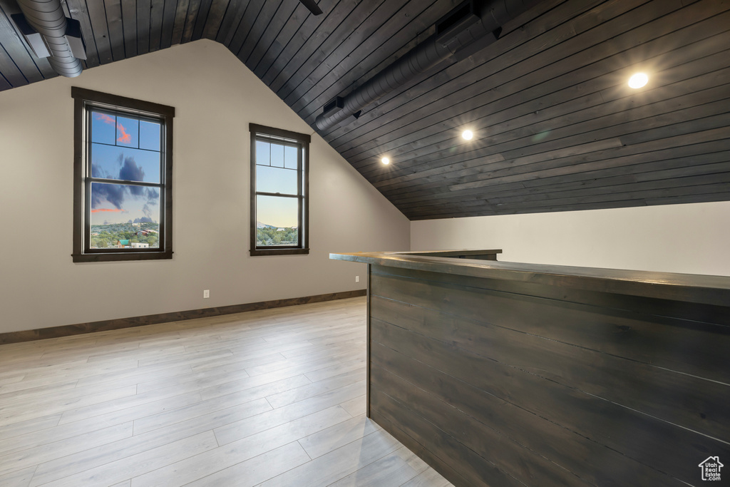 Additional living space featuring light hardwood / wood-style flooring and vaulted ceiling