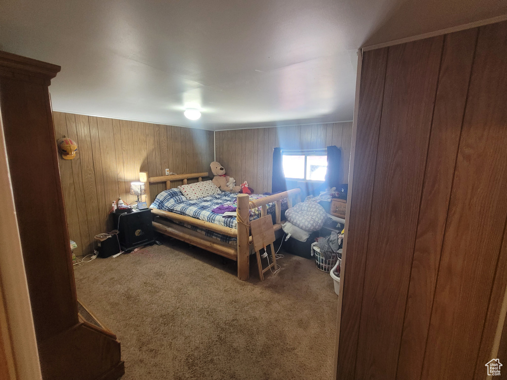 Bedroom with carpet floors and wooden walls