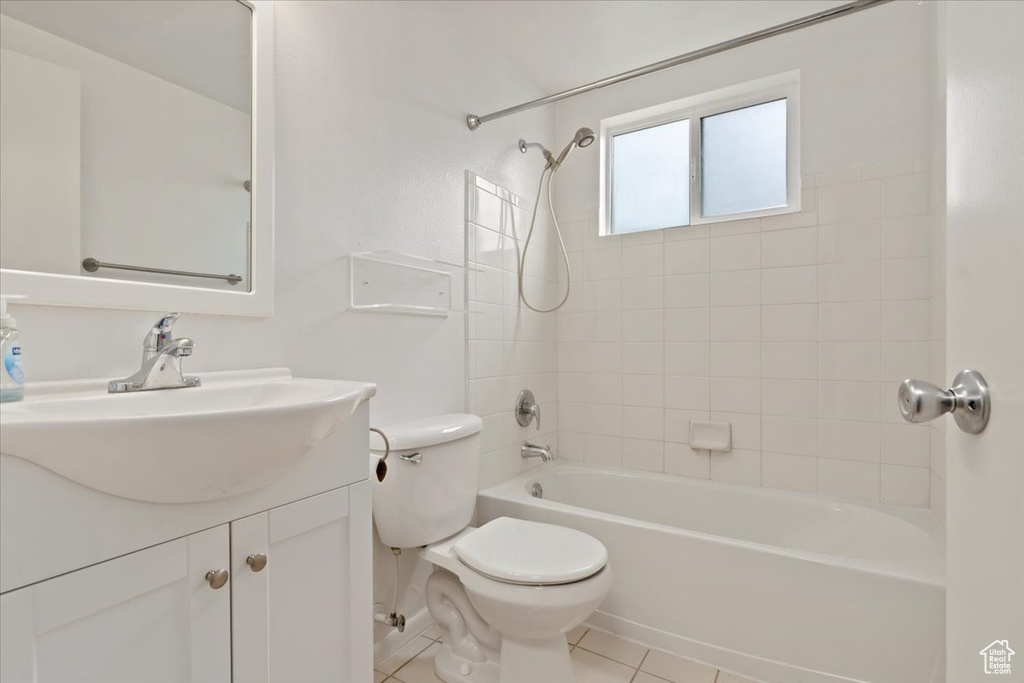 Full bathroom with tile floors, tiled shower / bath combo, toilet, and vanity