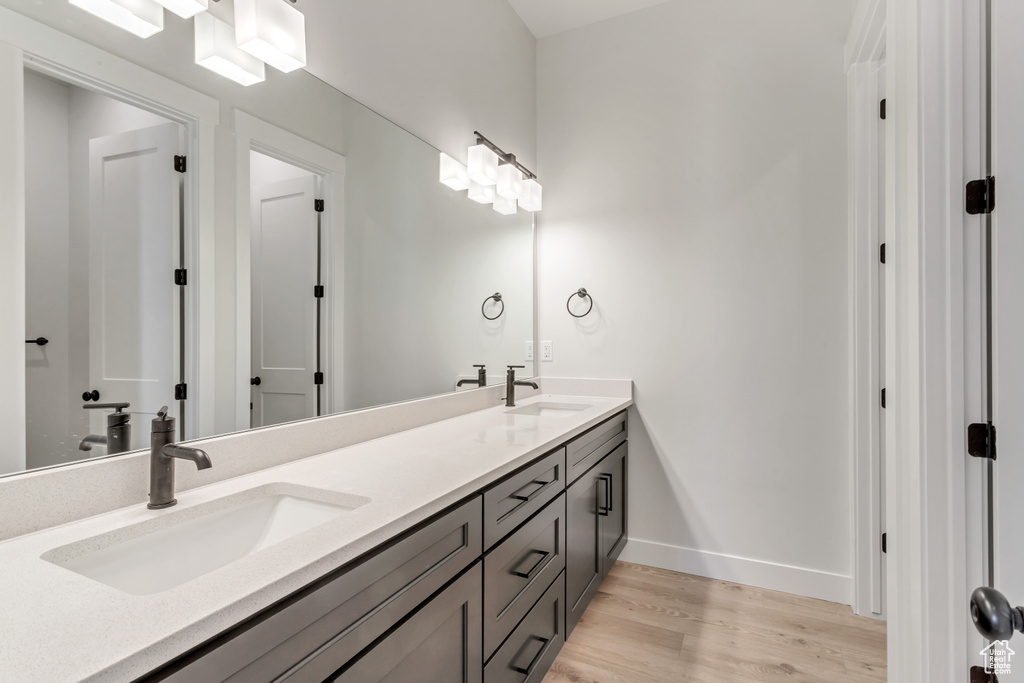 Bathroom with hardwood / wood-style floors, double sink, and large vanity