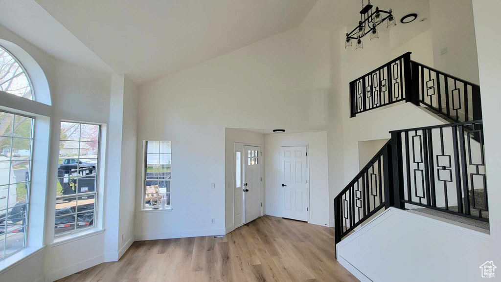 Entryway with light hardwood / wood-style floors and high vaulted ceiling