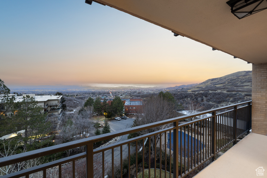Balcony at dusk featuring a mountain view