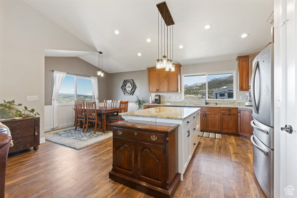 Kitchen with dark hardwood / wood-style flooring, hanging light fixtures, a center island, and plenty of natural light