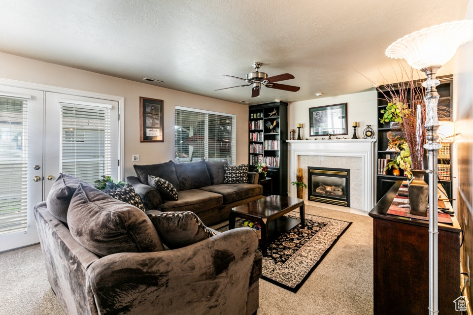 Living room featuring a wealth of natural light, light colored carpet, and a tile fireplace