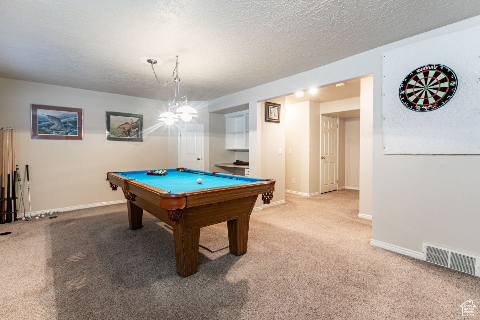 Playroom featuring light colored carpet, a textured ceiling, and pool table