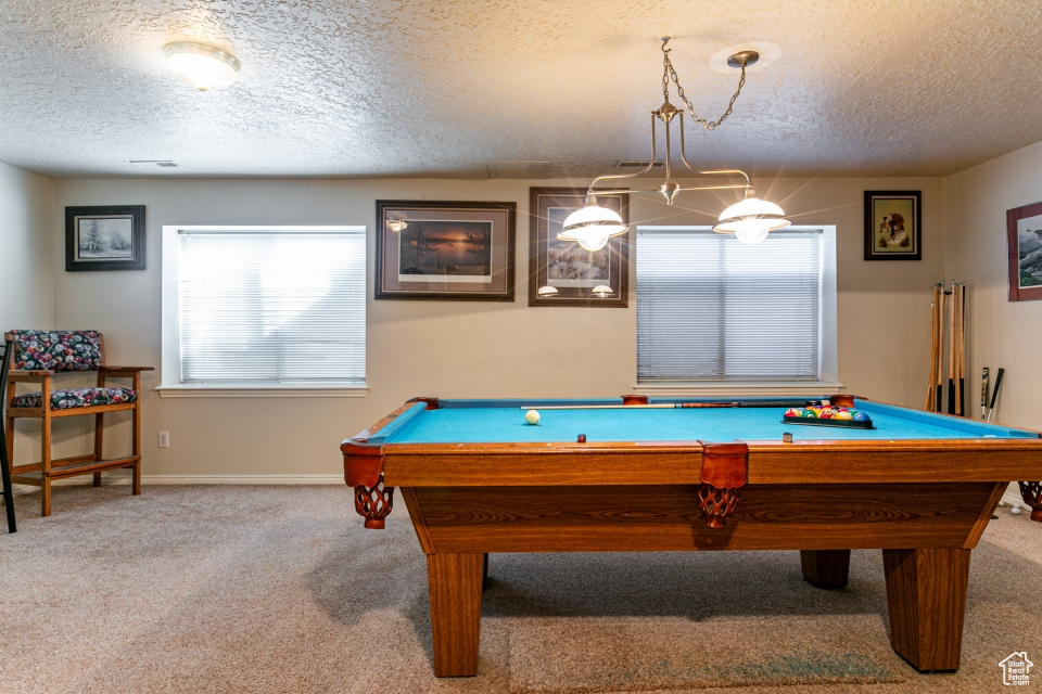 Recreation room with light carpet, a textured ceiling, and billiards