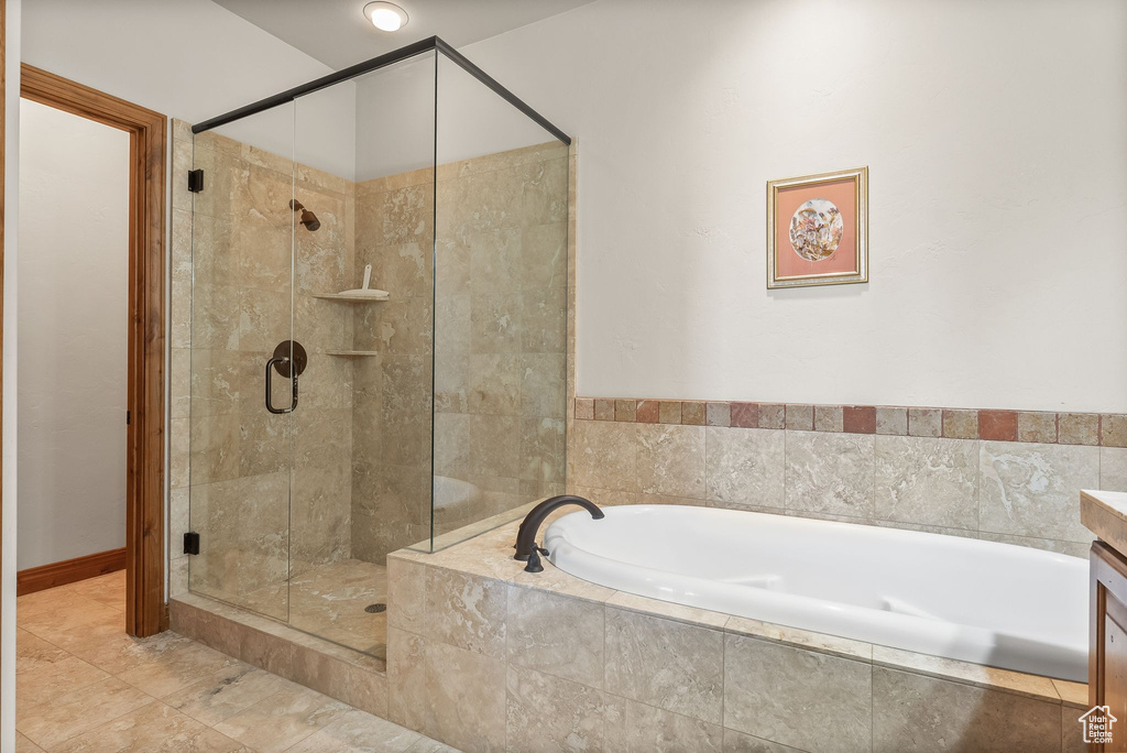 Bathroom with shower with separate bathtub, tile floors, and vanity
