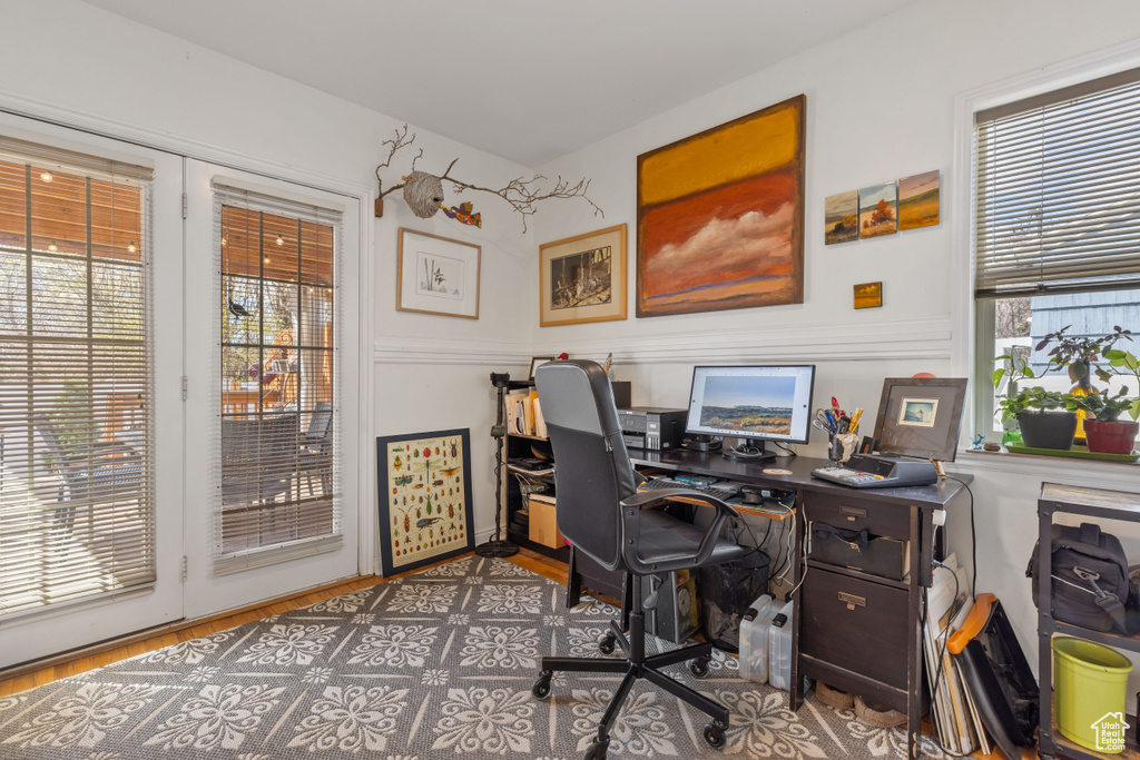 Office space with dark hardwood / wood-style flooring and a wealth of natural light