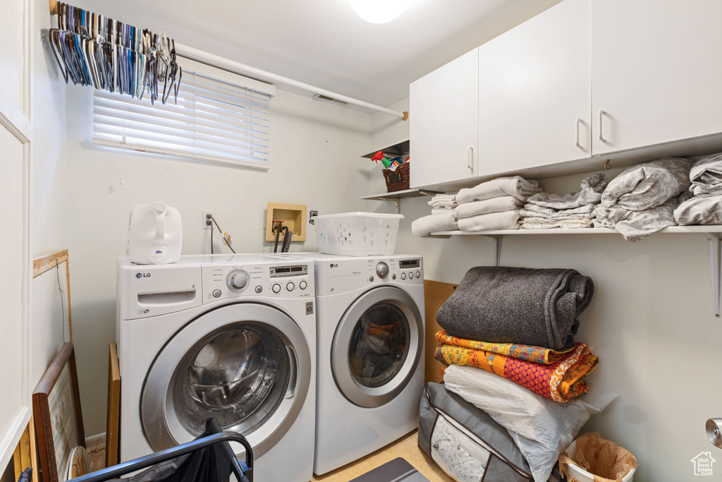 Clothes washing area with cabinets, hookup for a washing machine, and washer and clothes dryer