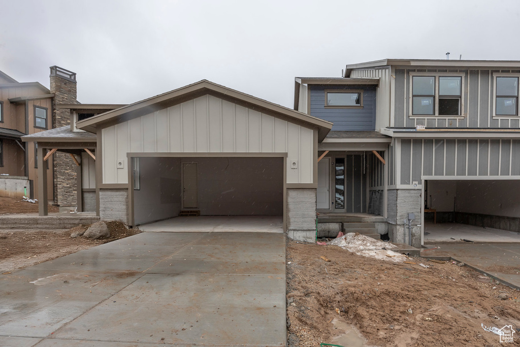 View of front of property featuring a garage, board and batten siding, and driveway
