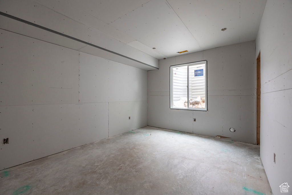 Spare room featuring unfinished concrete flooring