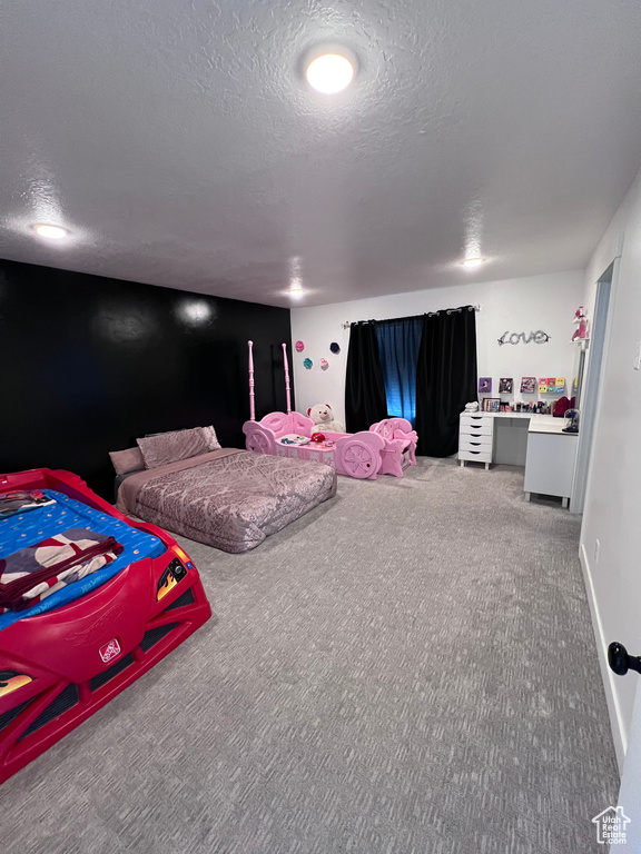 Bedroom featuring carpet and a textured ceiling