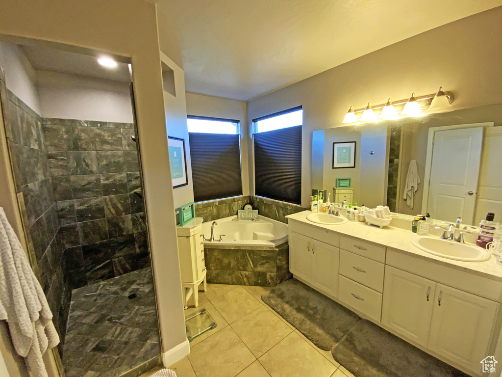 Bathroom featuring dual bowl vanity, tile flooring, and independent shower and bath