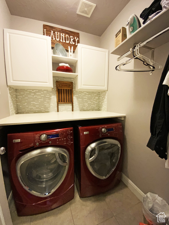 Clothes washing area with washing machine and dryer and light tile floors